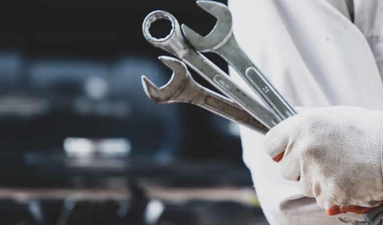 A QuickFit technician holding a set of spanners, ready to get to work.