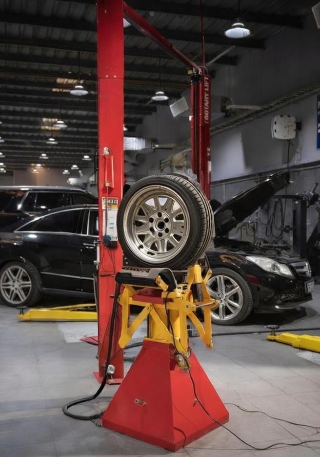 Wheel raised on a rotary lift during a tyre repair.