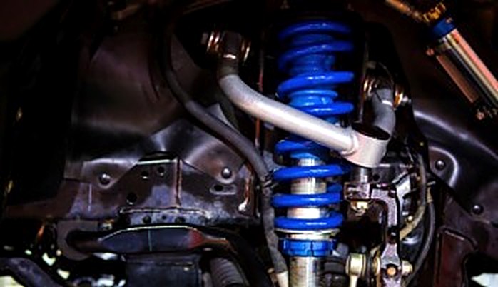 A vehicle's blue coilover shock absorber and suspension components.