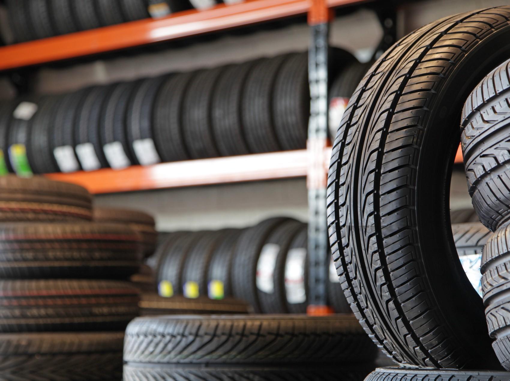 Rows of tyres stacked and racked in the QuickFit warehouse.